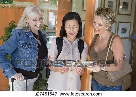 Stock Photo - Three women holding ticket on vacation. Fotosearch