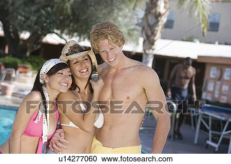 Three young friends relaxing at swimming pool View Large Photo Image Stock Image - Three young friends relaxing at swimming pool. Fotosearch