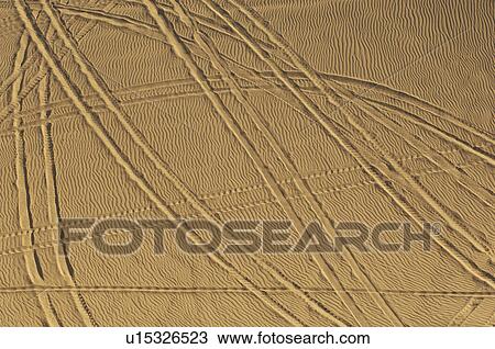 Stock Image - Tire tracks in sand, elevated view. Fotosearch