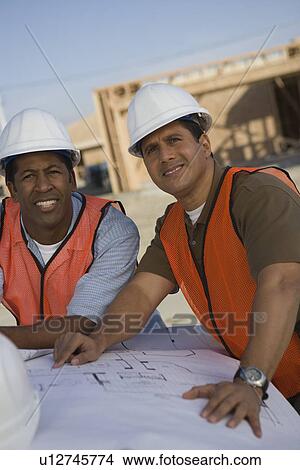 Two architects looking at blueprints View Large Photo Image Picture - Two architects looking at blueprints. Fotosearch