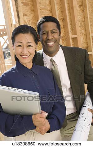 Stock Image - Two architects standing on construction site. Fotosearch