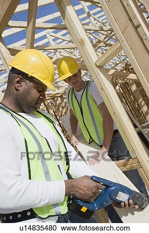 Stock Image - Two construction workers on site. Fotosearch