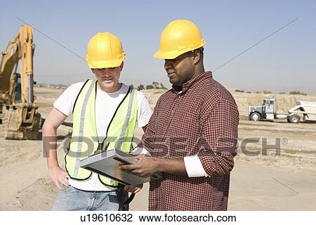 Stock Image - Two construction workers on site. Fotosearch