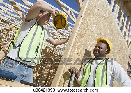 Stock Image - Two construction workers on site. Fotosearch