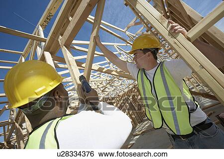 Two Construction Workers wearing hardhats, working on Site View Large Photo Image Stock Photograph - Two Construction Workers wearing hardhats, working on Site. Fotosearch