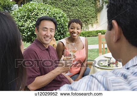 Two couples drinking wine in garden View Large Photo Image Stock Image - Two couples drinking wine in garden. Fotosearch