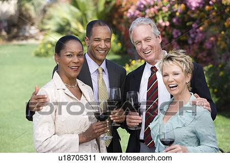 Two couples holding wine outdoors, portrait View Large Photo Image Stock Image - Two couples holding wine outdoors, portrait. Fotosearch