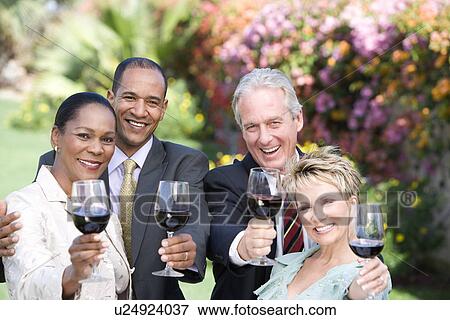 Two couples holding wine outdoors, portrait View Large Photo Image Stock Photo - Two couples holding wine outdoors, portrait. Fotosearch