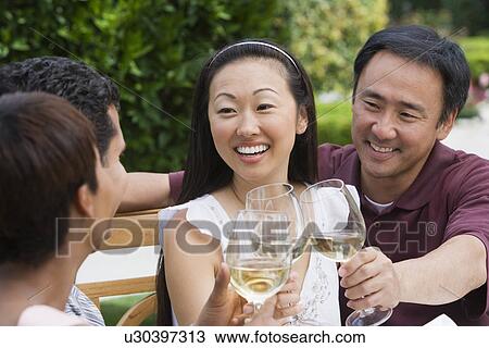 Two couples toasting in garden View Large Photo Image Stock Image - Two couples toasting in garden. Fotosearch