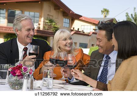 Two couples toasting outdoors View Large Photo Image Stock Image - Two couples toasting outdoors. Fotosearch