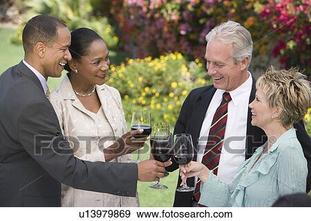 Stock Photo - Two couples toasting outdoors. Fotosearch