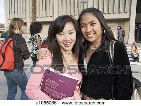 Stock Image - Two female students outside school, (portrait). Fotosearch