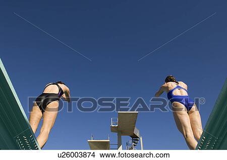 Two female swimmers standing on diving board View Large Photo Image Picture - Two female swimmers standing on diving board. Fotosearch