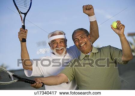 Two male tennis players cheering on court View Large Photo Image Stock Photo - Two male tennis players cheering on court. Fotosearch