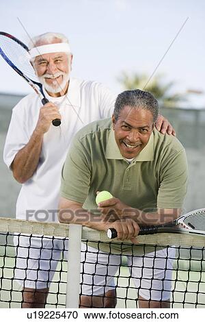 Stock Image - Two male tennis players on court. Fotosearch