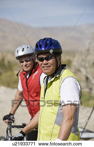 Two Senior men with bikes on road View Large Photo Image Stock Image - Two Senior men with bikes on road. Fotosearch