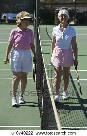 Stock Image - Two senior women on tennis court. Fotosearch