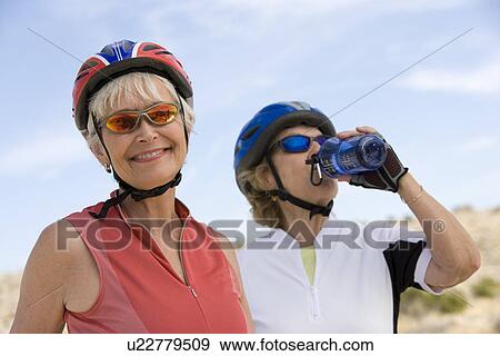 Stock Photo - Two Senior women wearing cycling helmets. Fotosearch