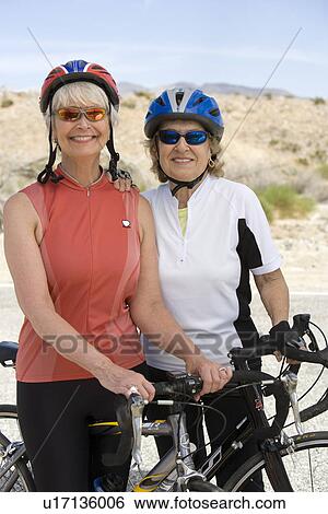 Stock Photograph - Two Senior women with bikes. Fotosearch