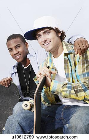 Two skateboarders sitting outside View Large Photo Image Stock Photo - Two skateboarders sitting outside. Fotosearch
