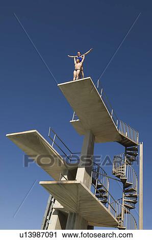 Two swimmers standing on diving board View Large Photo Image Stock Image - Two swimmers standing on diving board. Fotosearch