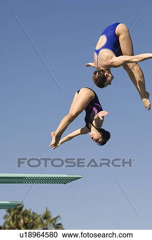 Two women diving from diving board View Large Photo Image Stock Image - Two women diving from diving board. Fotosearch
