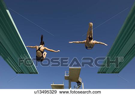 Stock Photo - Two women diving from diving board. Fotosearch