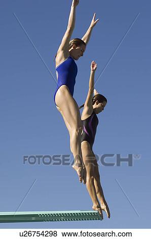 Stock Photo - Two women jumping on diving boards. Fotosearch