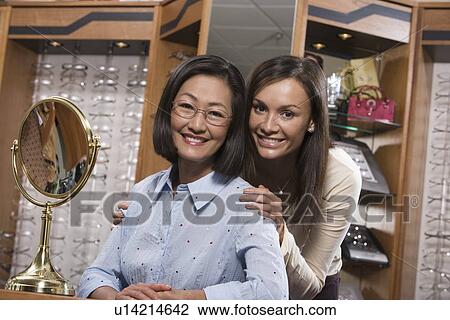 Two women trying on eyeglasses in store View Large Photo Image Stock Image - Two women trying on eyeglasses in store. Fotosearch