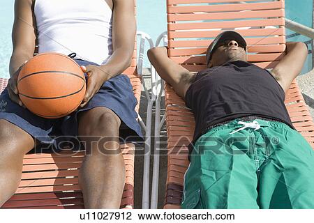 Two Young Man Relaxing on Sunlounger, One with Basketball View Large Photo Image Stock Image - Two Young Man Relaxing on Sunlounger, One with Basketball. Fotosearch
