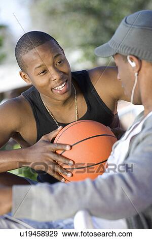 Stock Photo - Two Young Men with Basketball, Talking. Fotosearch