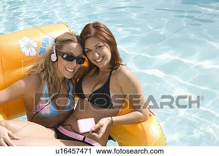 Two Young Women on Inflatable Raft in Pool, Portrait View Large Photo Image Stock Image - Two Young Women on Inflatable Raft in Pool, Portrait. Fotosearch