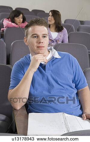 Stock Image - University student sitting in lecture hall. Fotosearch