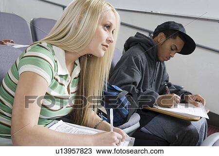 Stock Image - University students working in lecture hall. Fotosearch