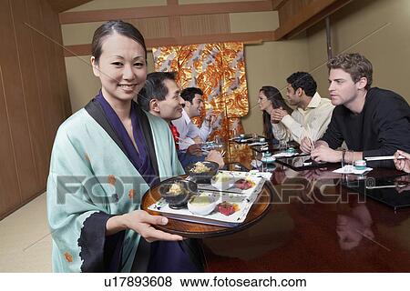 Stock Photo - Waitress serving sushi to restaurant. Fotosearch