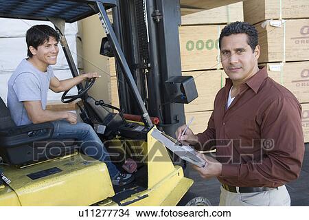 Picture - Warehouseman and forklift truck driver. Fotosearch