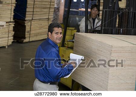 Stock Image - Warehouseman and forklift truck driver. Fotosearch