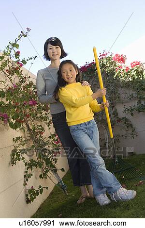 Woman and girl (10-12) in garden View Large Photo Image Stock Image - Woman and girl (10-12) in garden. Fotosearch