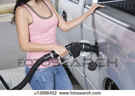 Woman by car with fuel pump, mid section View Large Photo Image Stock Image - Woman by car with fuel pump, mid section. Fotosearch