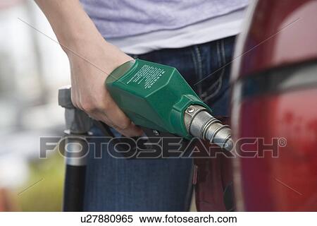 Woman by car with fuel pump, mid section View Large Photo Image Stock Photography - Woman by car with fuel pump, mid section. Fotosearch