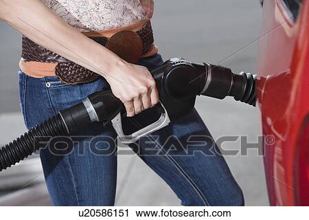 Woman by car with fuel pump View Large Photo Image Stock Image - Woman by car with fuel pump. Fotosearch