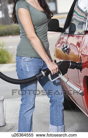 Woman by car with fuel pump View Large Photo Image Stock Photography - Woman by car with fuel pump. Fotosearch