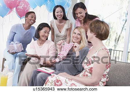 Stock Image - Woman Displaying a Gift at Her Baby Shower. Fotosearch