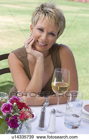 Stock Photo - Woman drinking wine outdoors, portrait. Fotosearch