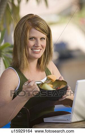 Picture - Woman Eating Bowl of Fruit. Fotosearch