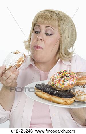 Stock Image - Woman Eating Donuts. Fotosearch