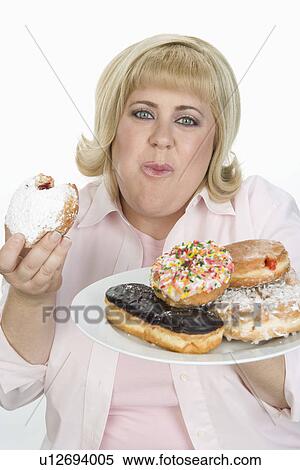 Stock Photography - Woman Eating Donuts. Fotosearch