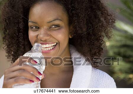Stock Image - Woman Holding Bottle of Water. Fotosearch
