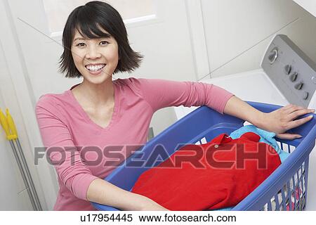 Woman holding laundry basket, portrait View Large Photo Image Stock Photography - Woman holding laundry basket, portrait. Fotosearch