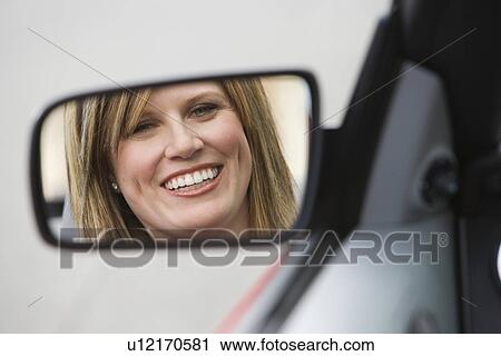 Stock Image - Woman in Side-View Mirror of Car. Fotosearch